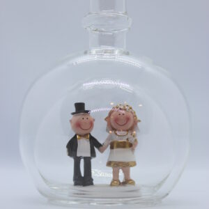 Eine leere bauchige Flasche aus Glas mit einem Goldenen Hochzeitspaar im Inneren.