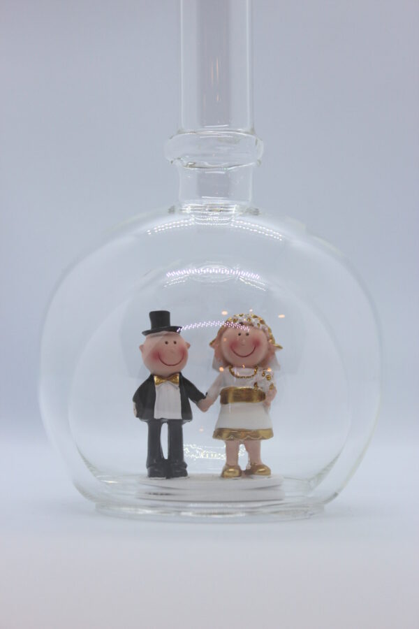 Eine leere bauchige Flasche aus Glas mit einem Goldenen Hochzeitspaar im Inneren.
