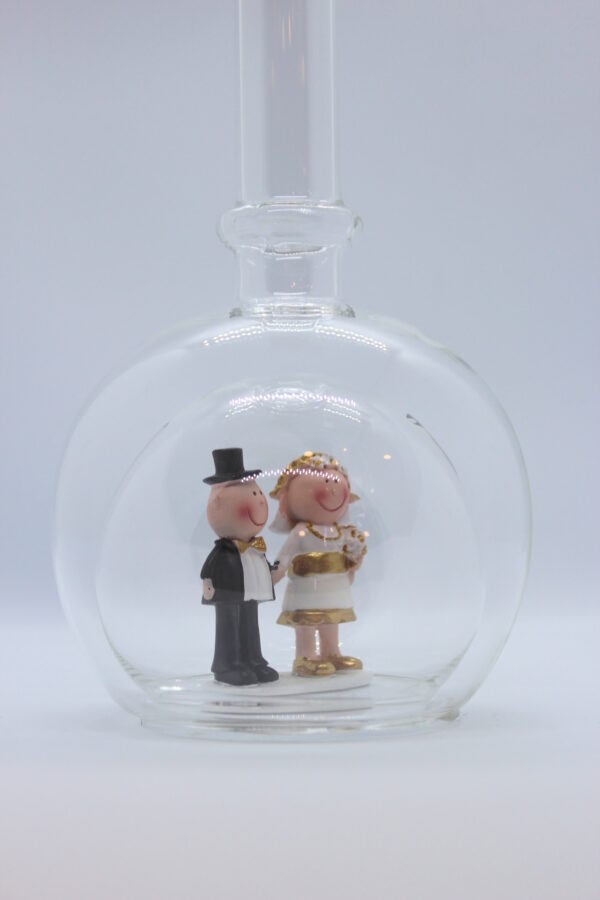 Eine leere bauchige Flasche aus Glas mit einem Goldenen Hochzeitspaar im Inneren.