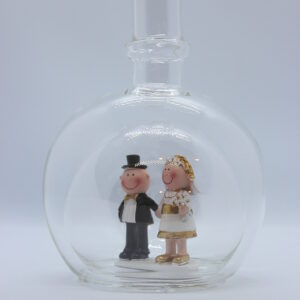 Eine leere bauchige Flasche aus Glas mit einem Goldenen Hochzeitspaar im Inneren.