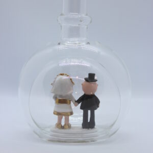 Eine leere bauchige Flasche aus Glas mit einem Goldenen Hochzeitspaar im Inneren.