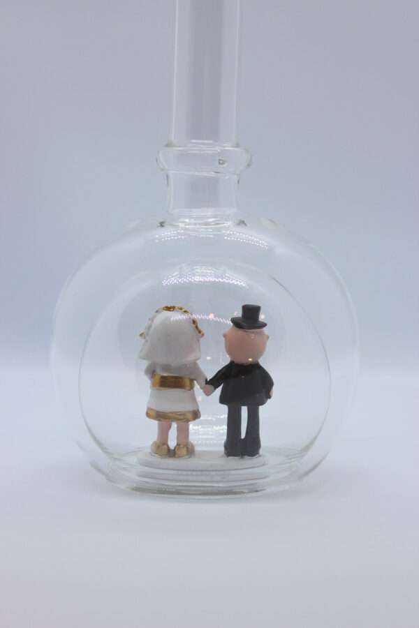 Eine leere bauchige Flasche aus Glas mit einem Goldenen Hochzeitspaar im Inneren.