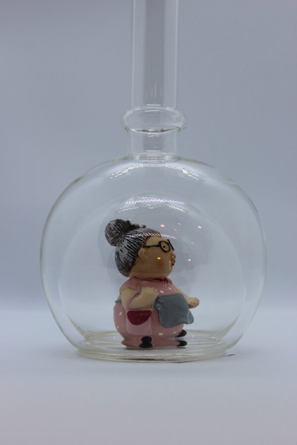 Eine leere bauchige Flasche aus Glas mit einer Oma im Inneren.