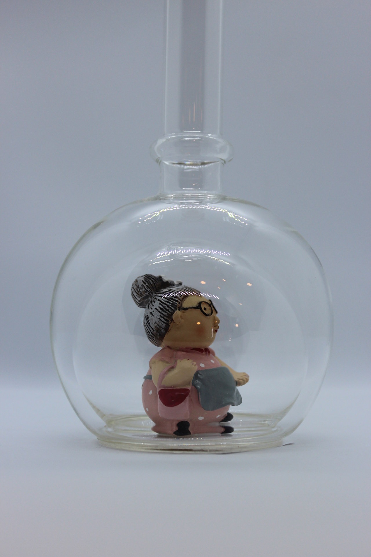 Eine leere bauchige Flasche aus Glas mit einer Oma im Inneren.