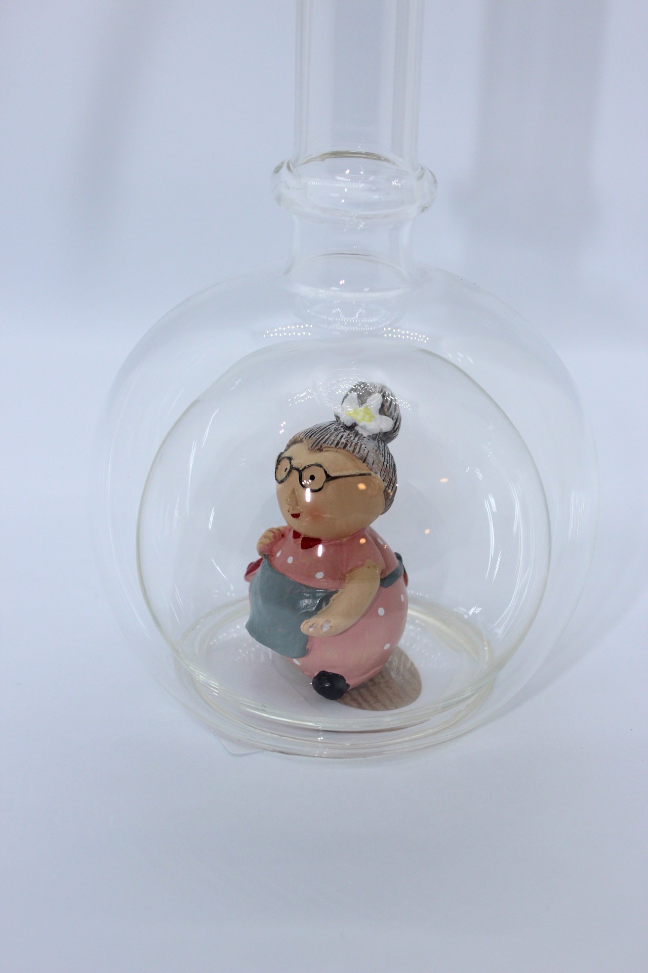 Eine leere bauchige Flasche aus Glas mit einer Oma im Inneren.