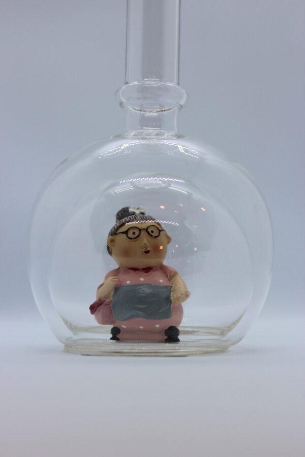 Eine leere bauchige Flasche aus Glas mit einer Oma im Inneren.