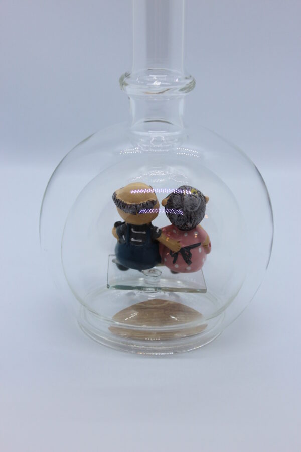 Eine leere bauchige Flasche aus Glas mit Oma und Opa im Inneren.