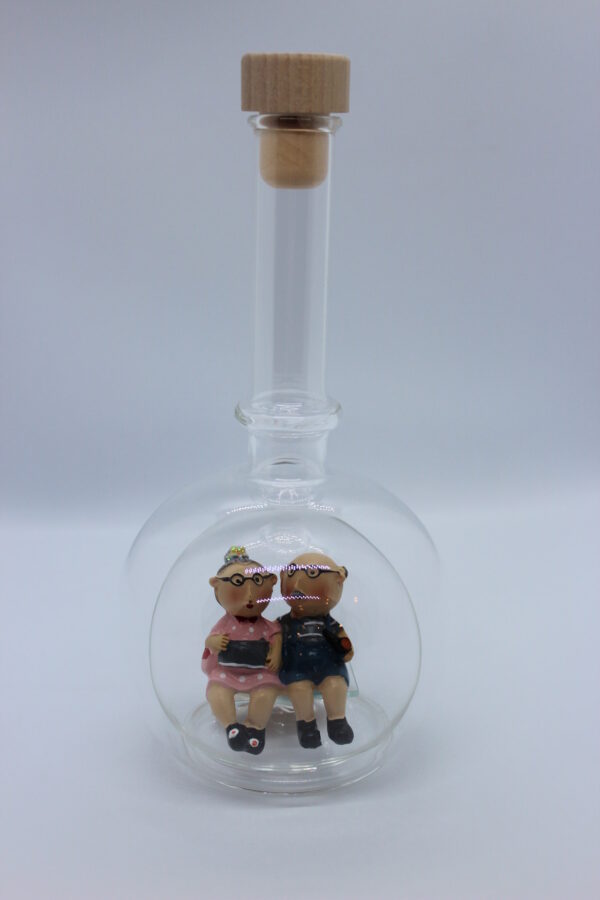 Eine leere bauchige Flasche aus Glas mit Oma und Opa im Inneren.