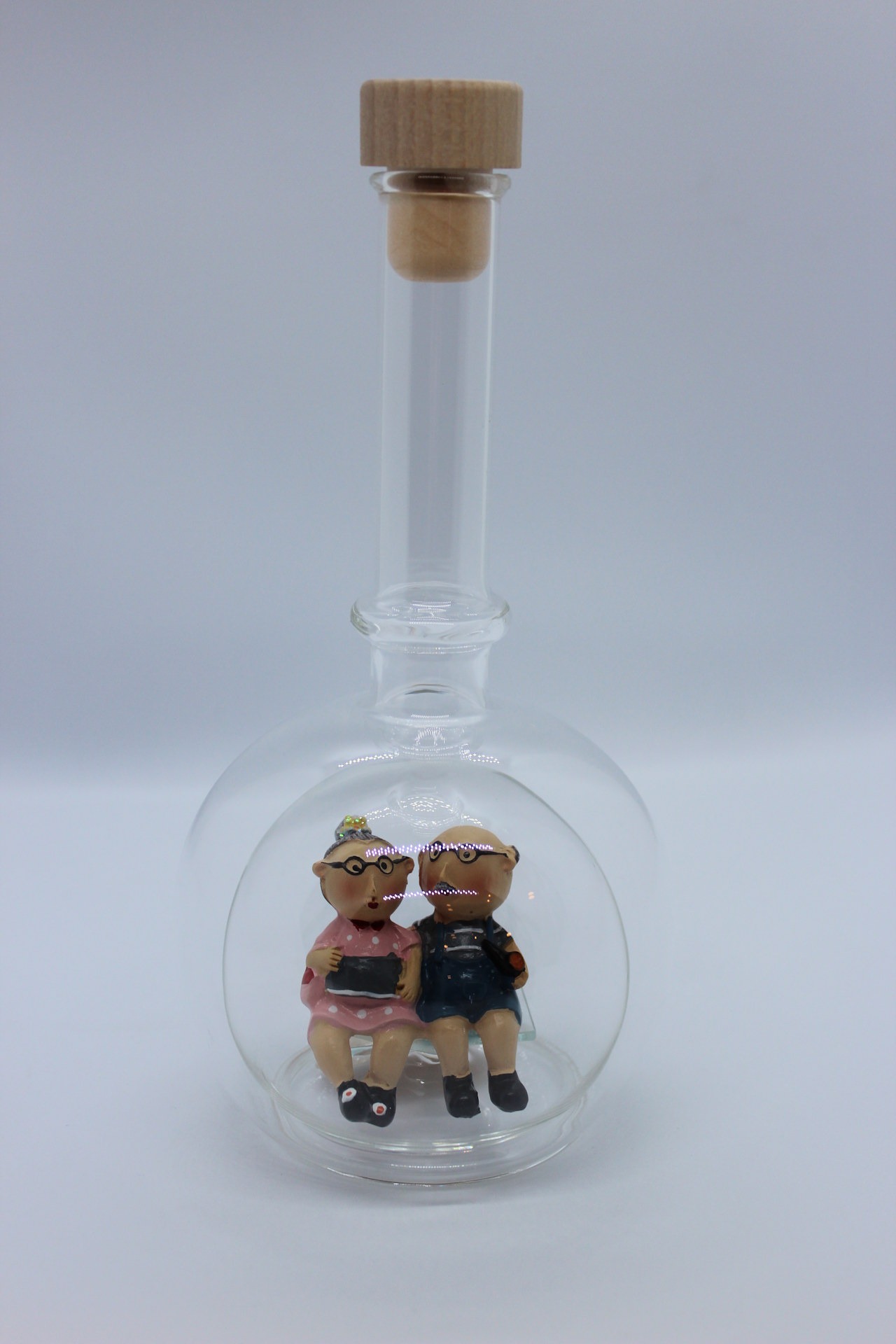 Eine leere bauchige Flasche aus Glas mit Oma und Opa im Inneren.