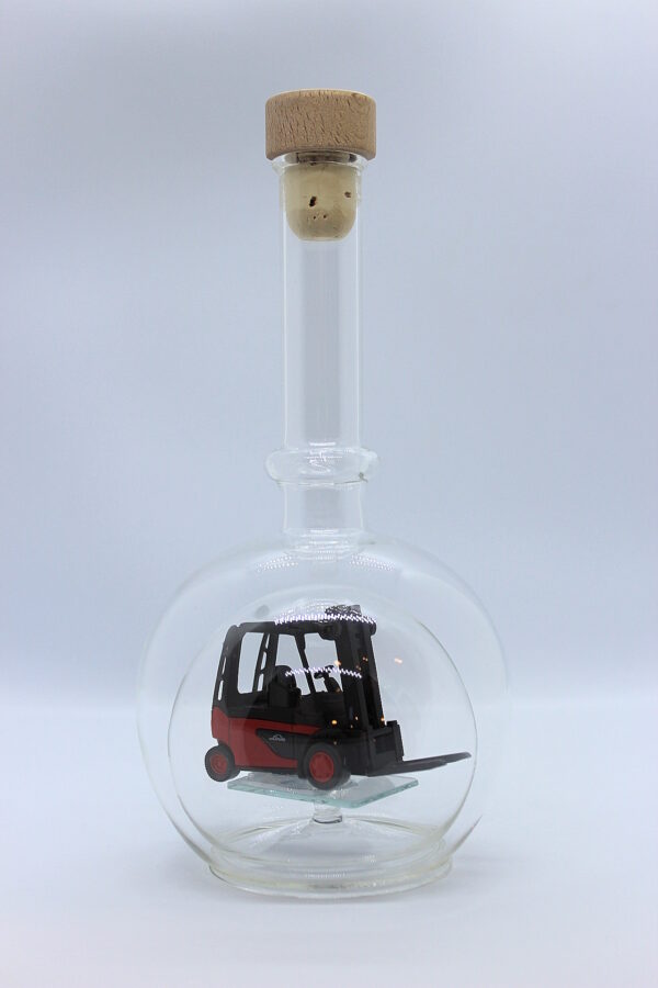 Eine leere bauchige Flasche aus Glas mit einem Stapler im Inneren.