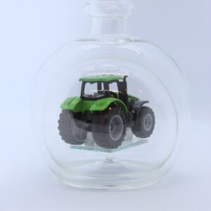 Eine leere bauchige Flasche aus Glas mit einem Deutz-Traktor im Inneren.