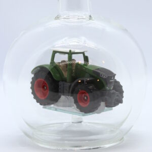 Eine leere bauchige Flasche aus Glas mit einem Fendt-Traktor im Inneren.