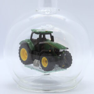 Eine leere bauchige Flasche aus Glas mit einem John-Deere-Traktor im Inneren.