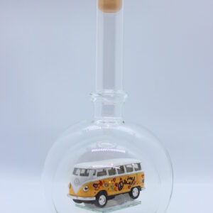 Eine leere bauchige Flasche aus Glas mit einem VW Bus T1 Flower in gelb im Inneren.
