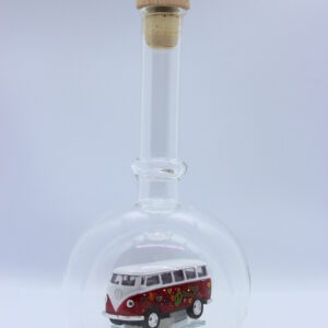 Eine leere bauchige Flasche aus Glas mit einem VW Bus T1 Flower in rot im Inneren.