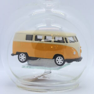 Eine leere bauchige Flasche aus Glas mit einem VW Bus T1 Samba in gelb im Inneren.