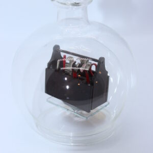 Eine leere bauchige Flasche aus Glas mit Werkzeugkasten Braun im Inneren.