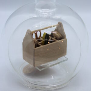 Eine leere bauchige Flasche aus Glas mit einem Werkzeugkasten Holz im Inneren.